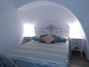 a bedroom with a bed with a white headboard at Kamares in Nardò