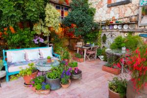 a garden with a blue couch and a bunch of plants at Fidanka Hotel in Kalkan