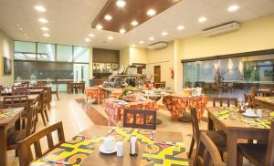 um restaurante com mesas e cadeiras de madeira e uma cafetaria em Wetiga Hotel em Bonito