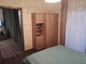 1 dormitorio con 1 cama y armario de madera en Apartament Nadmorski - Kompleks Pięć Mórz z basenem en Sianozety