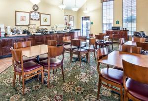 a restaurant with tables and chairs and a bar at Extended Studio Suites Hotel- Bossier City in Bossier City