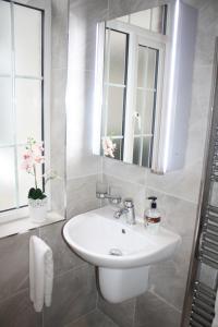 ein Badezimmer mit einem weißen Waschbecken und einem Spiegel in der Unterkunft Almanii in Dublin