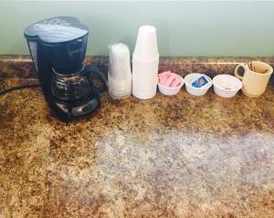 a coffee maker sitting on top of a counter with cups at Rock City Motel in Minneapolis