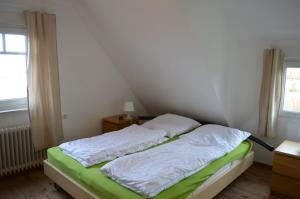 シリヒにあるOldeoogweg 7bのベッドルーム1室(白いシーツ付きのベッド1台、窓付)