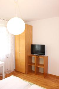 - un salon avec une télévision sur un meuble en bois dans l'établissement Haus Ilse & Karl Heinz, à Lasa