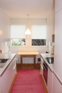 una cucina con tavolo e tappeto rosso di Haus Ilse & Karl Heinz a Lasa