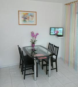 une salle à manger avec une table et des chaises en verre dans l'établissement FeWo Gan, à Rust