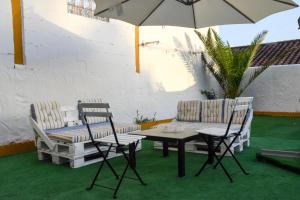 un patio con mesa, sillas y sombrilla en Vem Al Puerto De Santa Maria, en El Puerto de Santa María