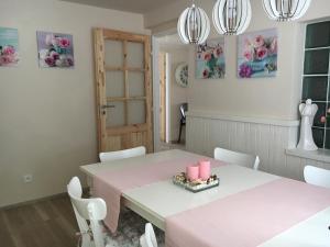 jadalnia z różowymi stołami i białymi krzesłami w obiekcie Vila Verunka w Pilznie