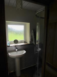 a bathroom with a sink and a window at Cae Eithin in Colwyn Bay