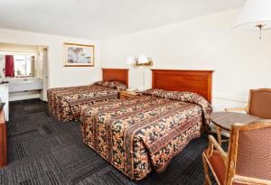Tempat tidur dalam kamar di Red Carpet Inn - Louisville