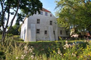 an old house in a field with trees at Event- Kultur & B&B Kunst Schloss Neuenhagen Übernachten im Denkmal in Bad Freienwalde