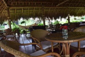 a restaurant with a table and chairs and a hammock at Palomino Breeze Hostal in Palomino