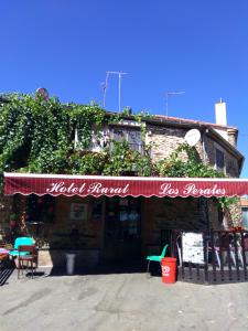 um restaurante com um toldo vermelho num edifício em Hotel Rural Los Perales em San Vitero