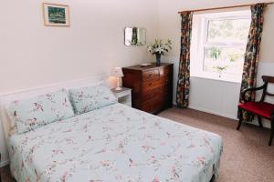 Kilry的住宿－Incheoch Farm Cottage，一间卧室配有一张床、一个梳妆台和一扇窗户。