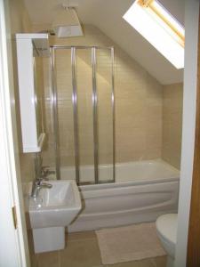 ein Badezimmer mit Dusche, Waschbecken und Toilette in der Unterkunft Finn Cottage in Strabane