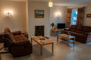 a living room with two couches and a fireplace at Finn Cottage in Strabane