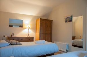 ein Schlafzimmer mit zwei Betten und einer Kommode in der Unterkunft Finn Cottage in Strabane