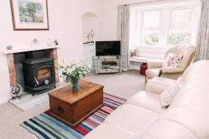 a living room with a white couch and a fireplace at Incheoch Farm Cottage in Kilry