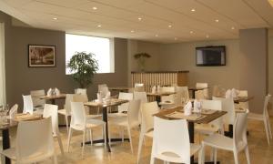 jadalnia ze stołami i białymi krzesłami w obiekcie Hotel San Remo w mieście Lima