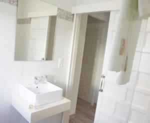 Un baño blanco con lavabo y espejo. en Casa Martina, en El Bosque 16 fotos más