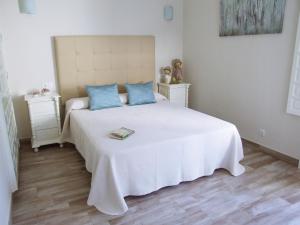 Un dormitorio con una gran cama blanca con almohadas azules. en Casa Martina, en El Bosque