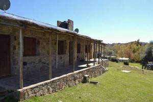 an old stone building with a stone wall at Hostal "El Tomolasta" in La Carolina