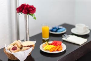 une table avec des plaques alimentaires et un verre de jus d'orange dans l'établissement Hotel Parador Zacatecas, à Zacatecas