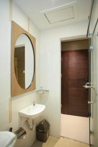 y baño con lavabo y espejo. en JLE'S Hotel, en Manado