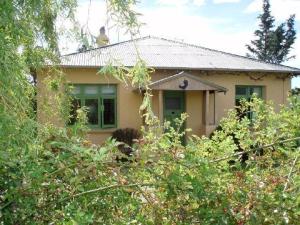 una casa amarilla con árboles delante de ella en Muddy Creek Cutting en Lauder