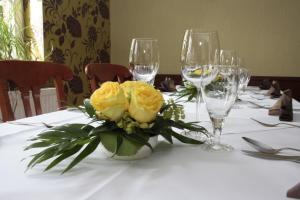un tavolo con rose gialle e bicchieri da vino di Hotel Bützower Hof a Bützow