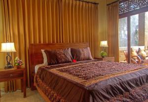 a bedroom with a large bed and a window at Lily Lane Villas in Ubud