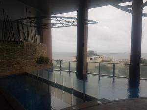 a swimming pool with a view of the ocean from a building at Eton Baypark in Manila