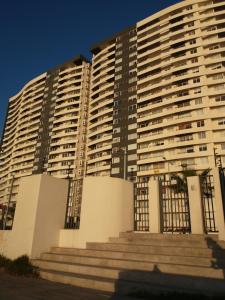 un gran edificio de apartamentos con escaleras delante en Departamento en Playa La Herradura, en Coquimbo