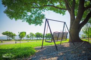 a swing hanging from a tree in a park at Simple Life in Yuli