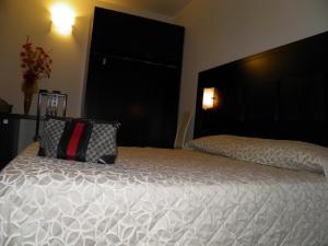 a bed with a black headboard and a pillow on it at Hotel I Crespi in Grosseto