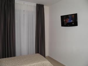 a bedroom with a bed and a tv on the wall at Hotel I Crespi in Grosseto