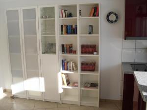 a white book shelf with books in a kitchen at Apartment Sonnenschein in Braunlage