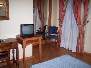 a living room with a tv and a table and chairs at Castillo Lanjaron in Lanjarón