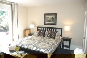 - une chambre avec un lit et une table avec deux lampes dans l'établissement Windsor Guest House, à Vancouver