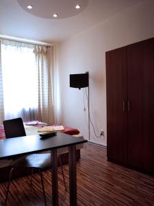 ブダペストにあるTop Apartment Budapestのテーブル、キャビネット、ベッドが備わる客室です。