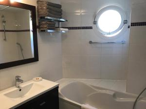 ein Badezimmer mit einer Badewanne, einem Waschbecken und einem Spiegel in der Unterkunft Villa Lina in Bandol