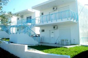 a white house with a blue staircase in front of it at Villagiannis in Nea Fokea
