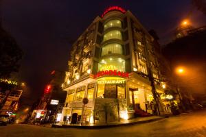 een groot gebouw met neonlichten op een straat bij Le Bordeaux Sapa Hotel in Sa Pa