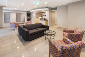 a living room filled with furniture and a table at City Edge Dandenong Apartment Hotel in Dandenong