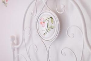 een witte plaat met een bloemontwerp op een muur bij DUSSAIGA - Camera Delle Rose in Dolceacqua