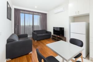 a living room filled with furniture and a tv at City Edge Dandenong Apartment Hotel in Dandenong