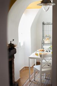 un tavolo bianco con sedie in una stanza di DUSSAIGA - Camera Delle Rose a Dolceacqua