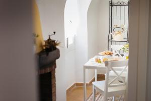una sala da pranzo bianca con tavolo e sedie bianchi di DUSSAIGA - Camera Delle Rose a Dolceacqua Altre 10 foto