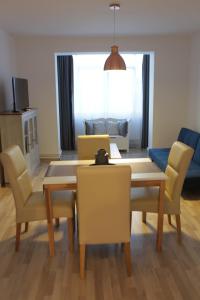 a living room with a dining room table and chairs at Joy Apartment in Timişoara